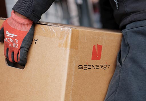 Apex Power Supplies magazijn medewerker met een Sigenergy doos