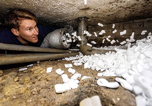 SolarNRG monteur plaatst isolatiechips in een kruipruimte