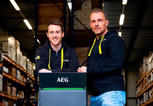 Mark Post en Sander Noordermeer met een AEG thuisbatterij voor het magazijn van SolarNRG