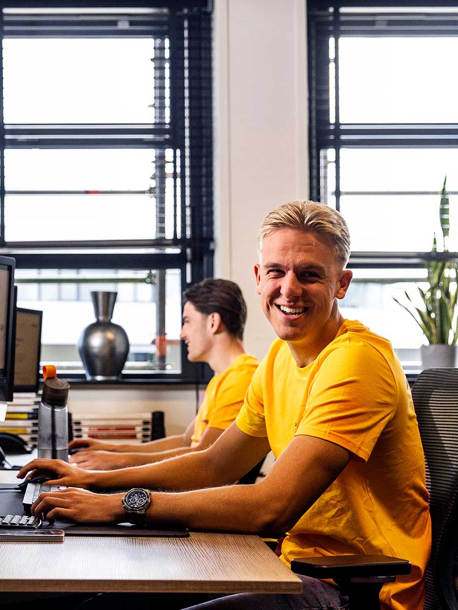 SolarNRG zonnepanelen expert glimlachend achter zijn bureau